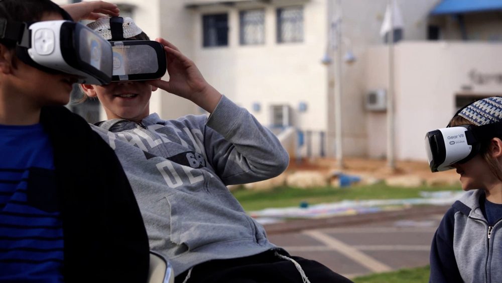 שורת תלמידים חובשים משקפי מציאות מדומה בפעילות בחצר בית הספר
