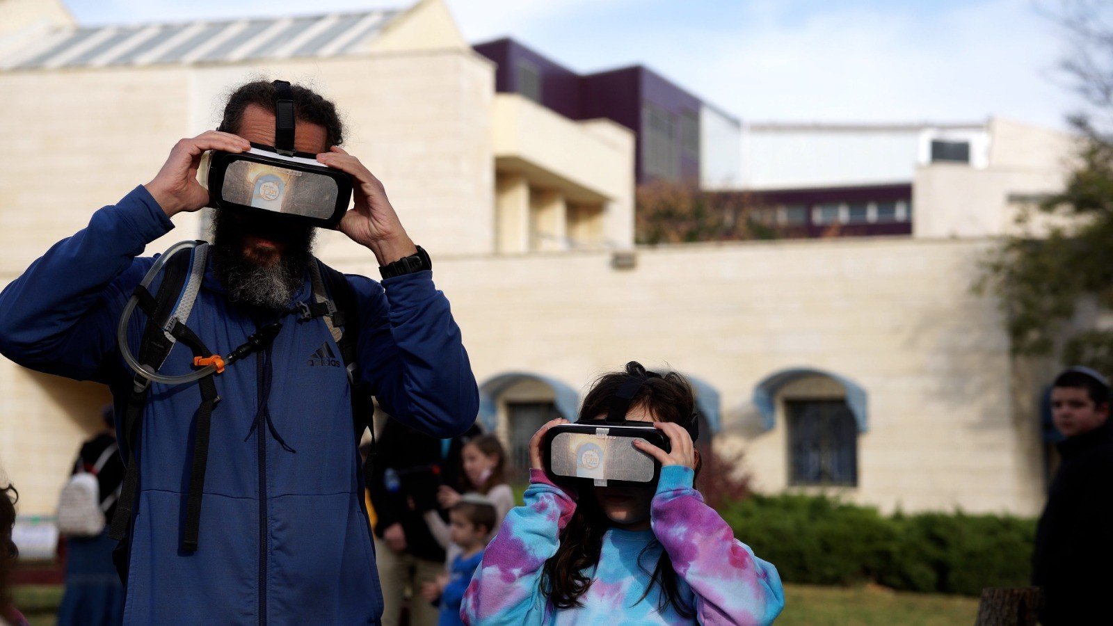 תלמידים חובשים משקפי מציאות מדומה בחצר בית הספר במהלך פעילות בריחה.נט